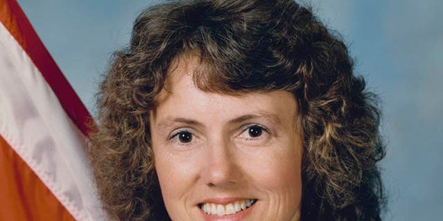 Christa McAuliffe (1948-1986), wearing a blue NASA jumpsuit, smiles in a studio portrait while holding a model of a space shuttle at Johnson Space Center in Houston, Texas, on Sept. 26, 1985. She was the first private citizen to go into space on the shuttle.