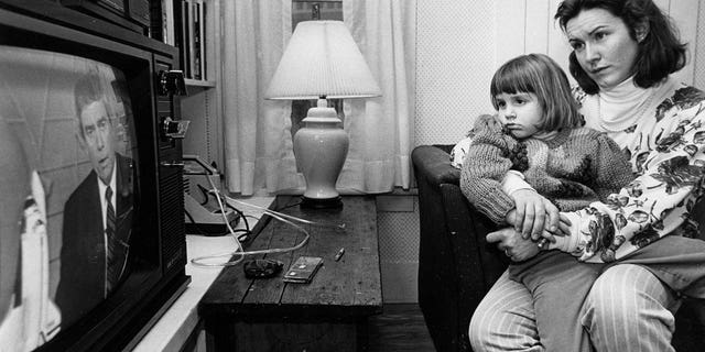 Mandana Marsh holds her daughter, Molly, 4, as they watched TV coverage hours after the explosion of the space shuttle Challenger inside their home in Concord, New Hampshire, on Jan. 28, 1986. When her mother explained what happened, young Molly asked, "Can't Christa swim?" 