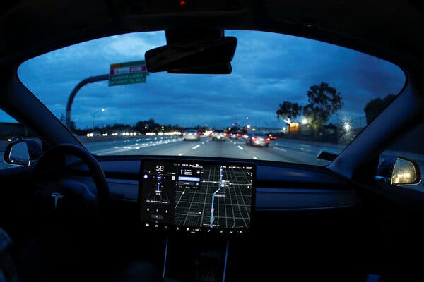 A view from the passenger compartment through the windshield of a Tesla, with a navigation display mounted on the dashboard.